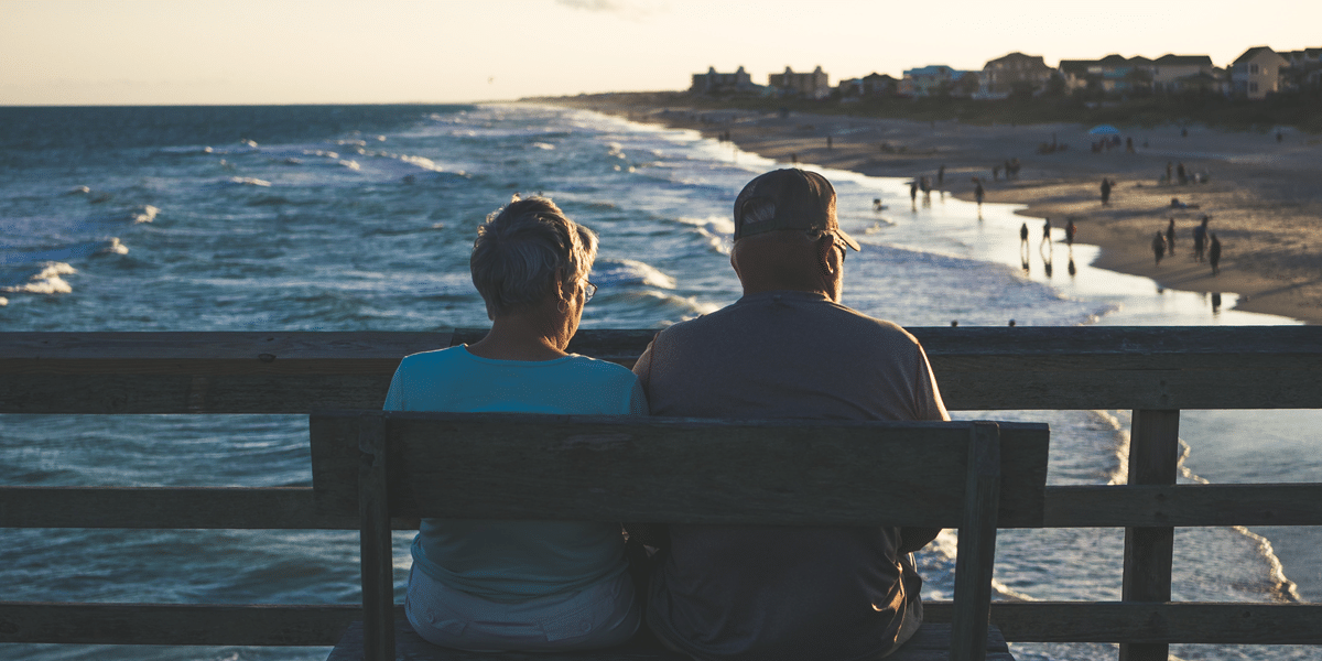 Image commercially licensed from: https://unsplash.com/photos/man-and-woman-sitting-on-bench-in-front-of-beach-6D58t6uZT5M